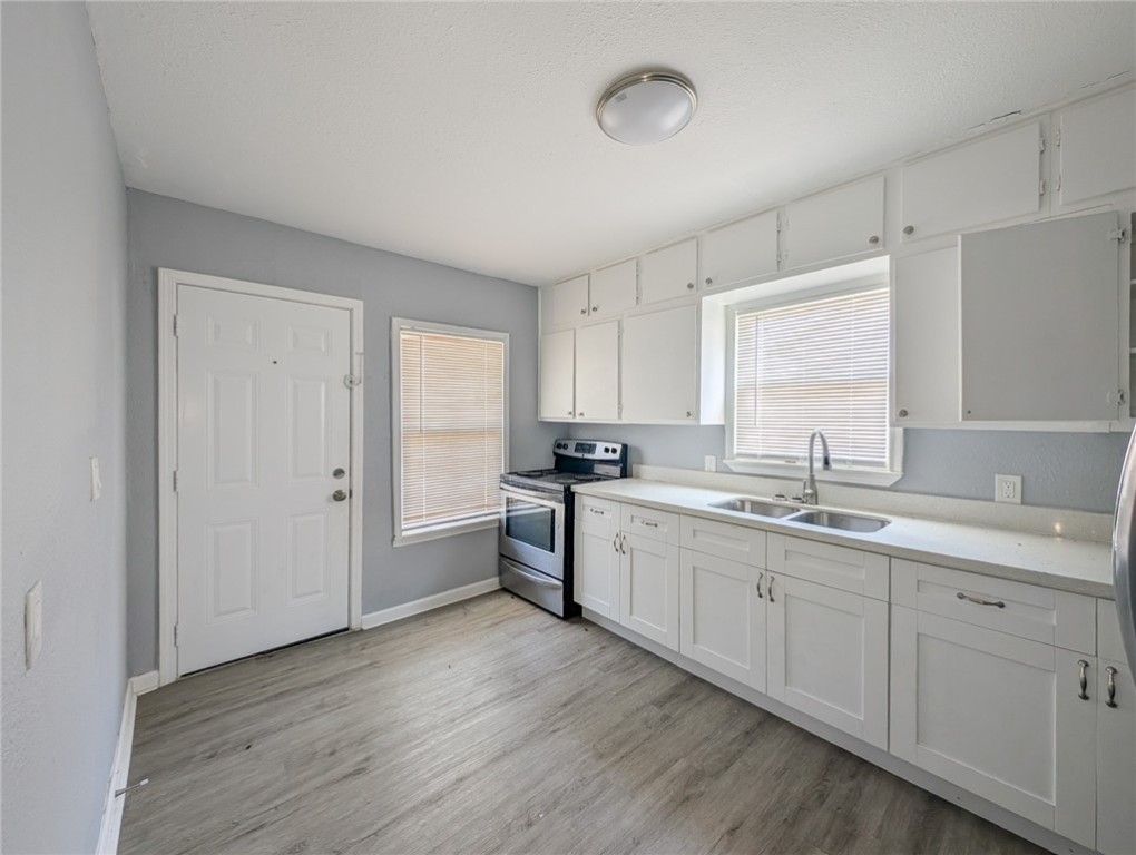 4709 Archer Drive Corpus Christi, TX 78415 - Photo 4 of 17 a large white kitchen with a sink and dishwasher a stove with wooden floor