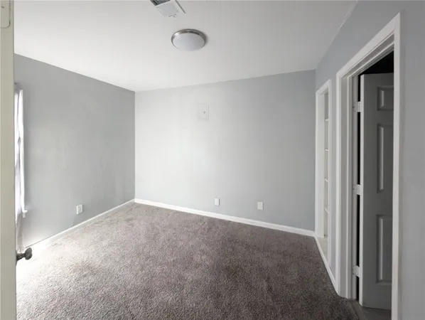 a view of an empty room with closet area
