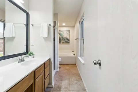 a bathroom with a bathtub shower sink and mirror