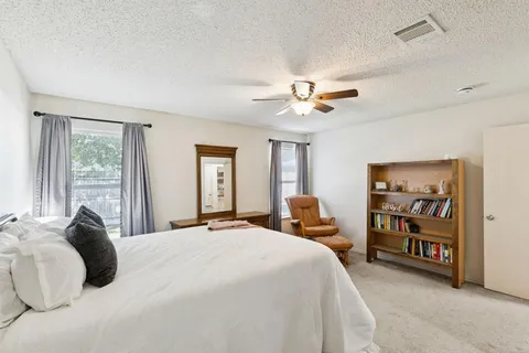 a bedroom with a large bed and a chandelier