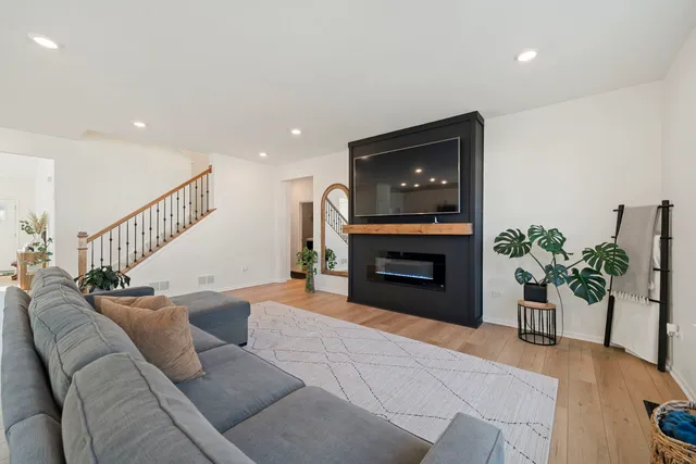 a living room with furniture a potted plant and a fireplace