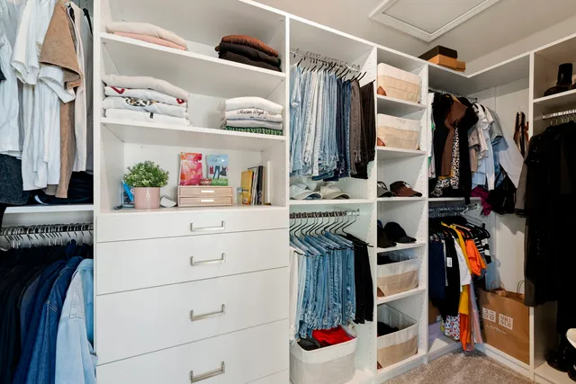 a view of walk in closet with clothes and shoes