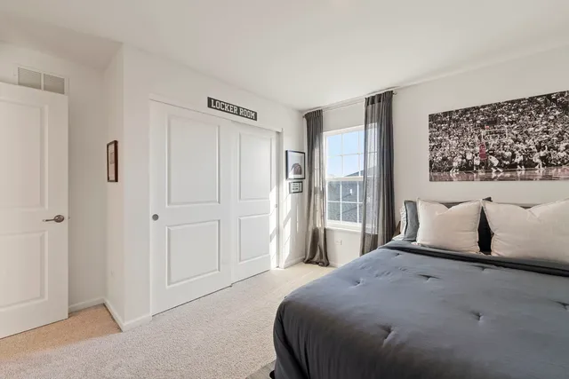 a bedroom with a large bed and a painting on the wall