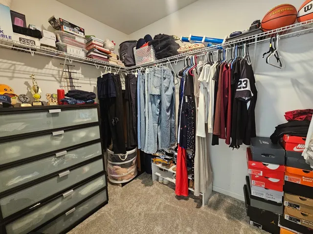 a view of walk in closet with clothes and shoes