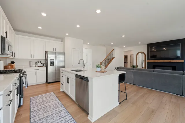 a kitchen with stainless steel appliances kitchen island granite countertop a refrigerator and a stove top oven