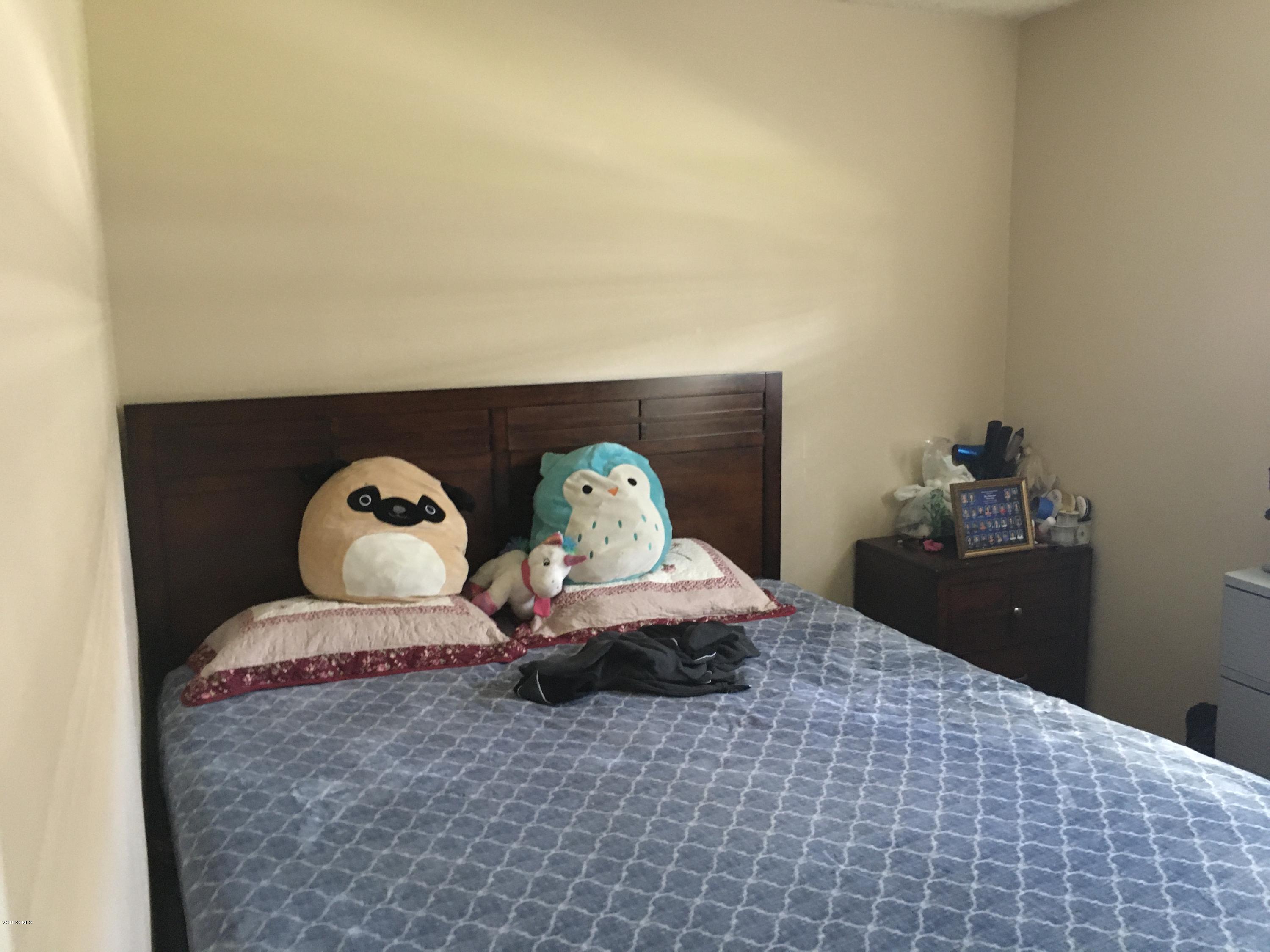 520 Spring Road, Unit 109 Moorpark, CA 93021 - Photo 4 of 8 a bedroom with a bed and a mirror