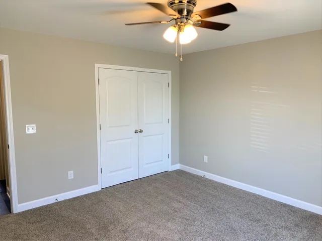 an empty room with a window and a fan