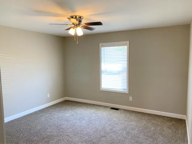 an empty room with a chandelier fan
