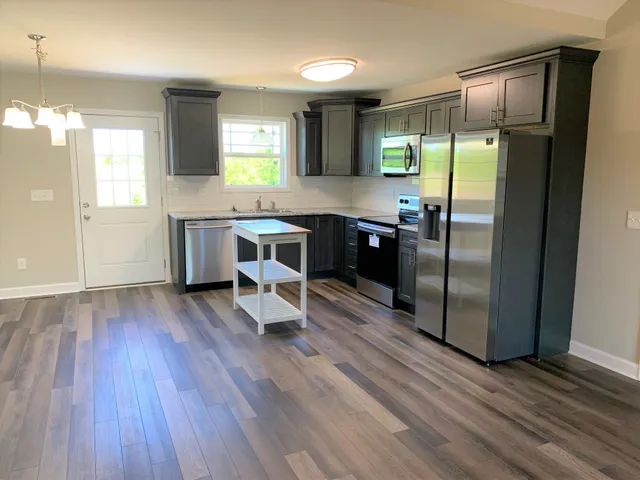 an empty room with wooden floor mirror and window
