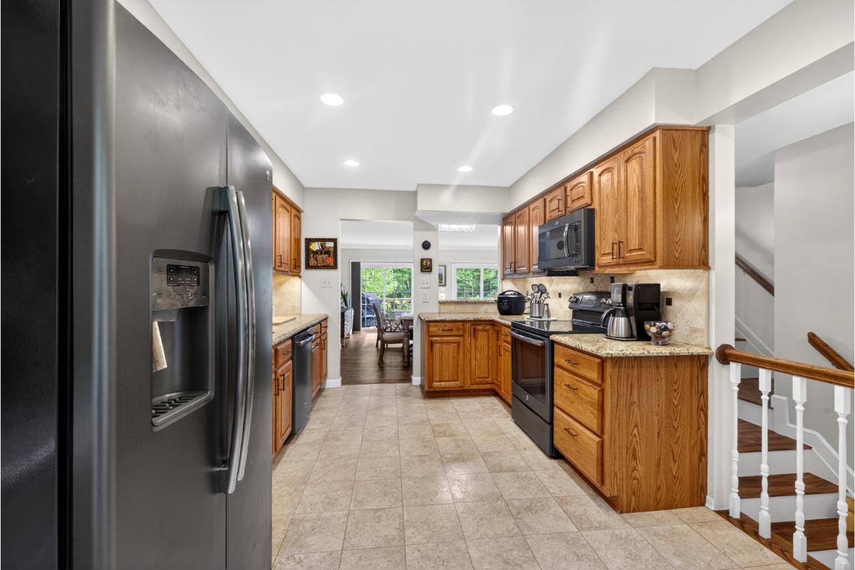 7347 Swan Point Way, Unit 122 Columbia, MD 21045 - Photo 13 of 54 a kitchen with stainless steel appliances granite countertop a refrigerator and a stove top oven