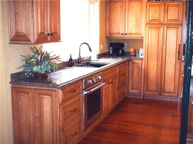 6040 Temple Road Nashville, TN 37221 - Photo 5 of 20 Countertops and backsplash are Sliestone Rainforest, Custom Palomino colored Camden Maple cabinets
