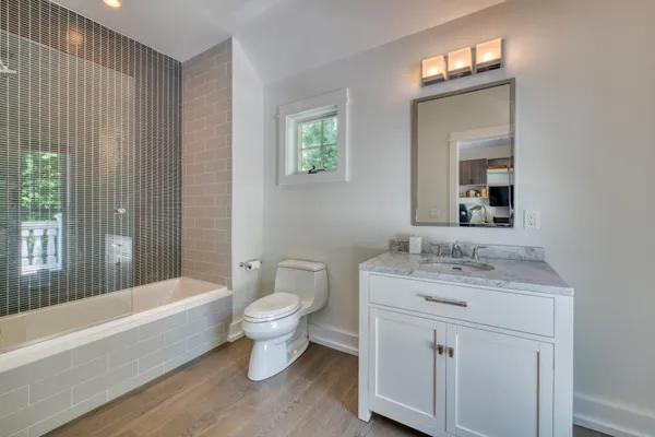 a bathroom with a granite countertop toilet a sink and bathtub