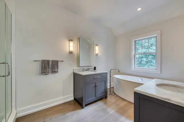 a spacious bathroom with a granite countertop sink mirror and bathtub