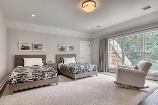 a bedroom with two beds and a large window