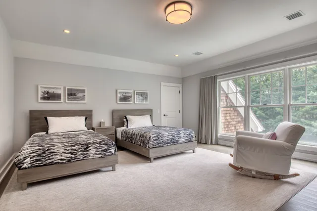 a bedroom with two beds and a large window