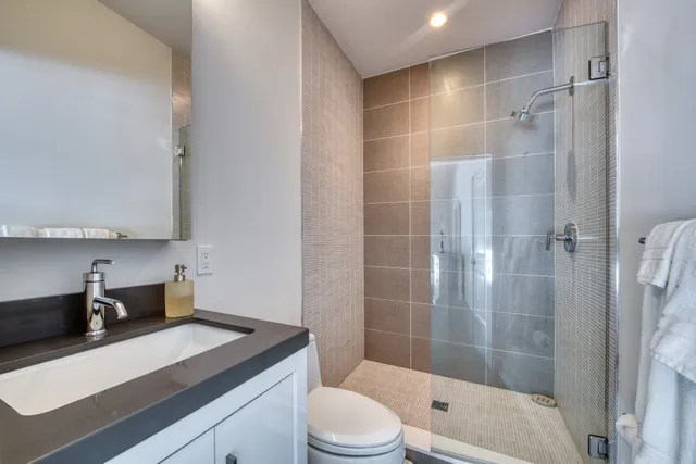 a bathroom with a sink a toilet and shower