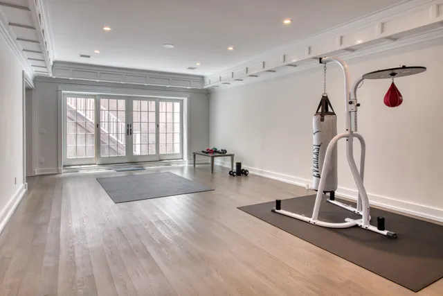 a room with gym equipment and large mirror