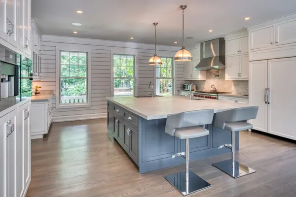 a kitchen with stainless steel appliances granite countertop a stove a sink a refrigerator and a wooden cabinets