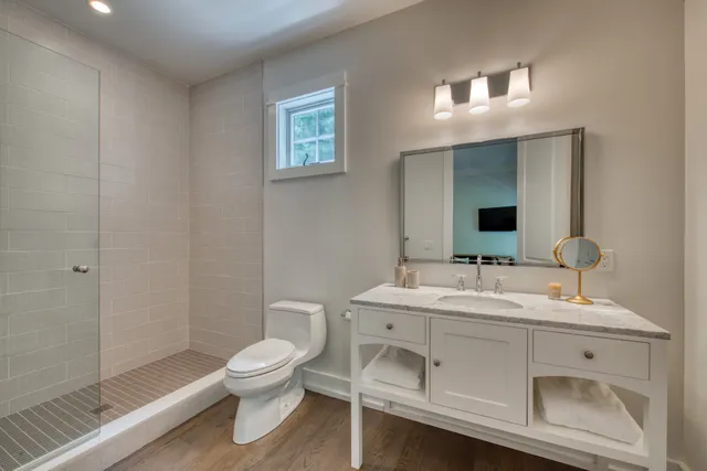 a bathroom with a toilet sink and mirror