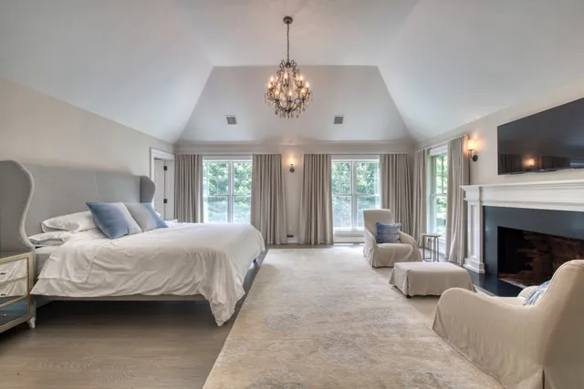 a bedroom with a large bed and a fireplace