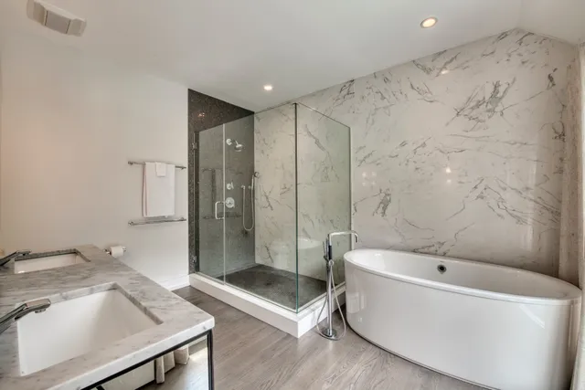 a bathroom with a tub a sink and a shower