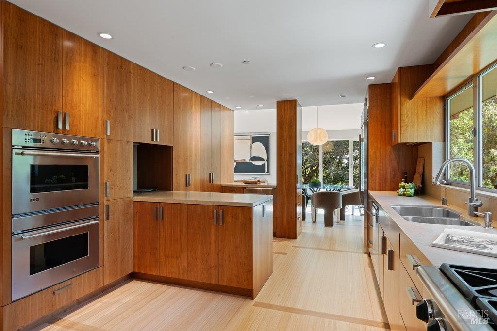 103 Reed Ranch Road Tiburon, CA 94920 - Photo 18 of 89 a large kitchen with stainless steel appliances a stove a sink dishwasher a microwave oven with cabinets and wooden floor