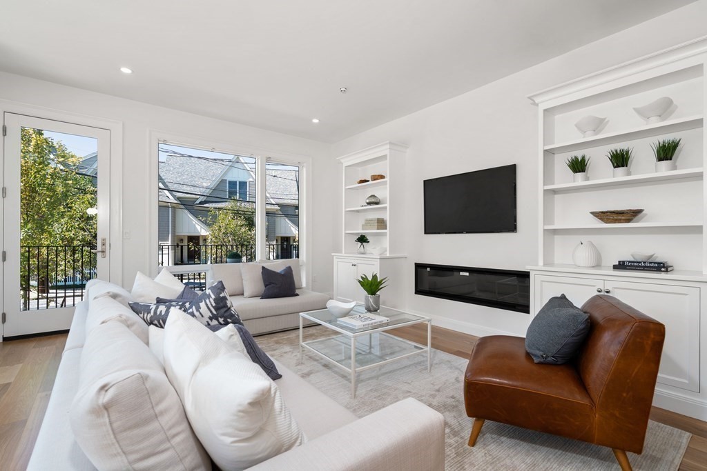 400 Hunnewell Street, Unit 103 Needham, MA 02494 - Photo 12 of 20 a living room with furniture a flat screen tv and a large window