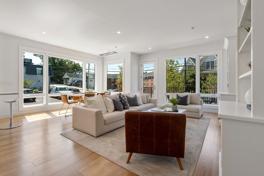 400 Hunnewell Street, Unit 103 Needham, MA 02494 - Photo 9 of 20 a living room with furniture large windows and wooden floor