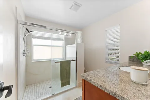 a bathroom with a granite countertop sink and a mirror