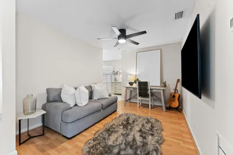 a living room with furniture a flat screen tv and kitchen view