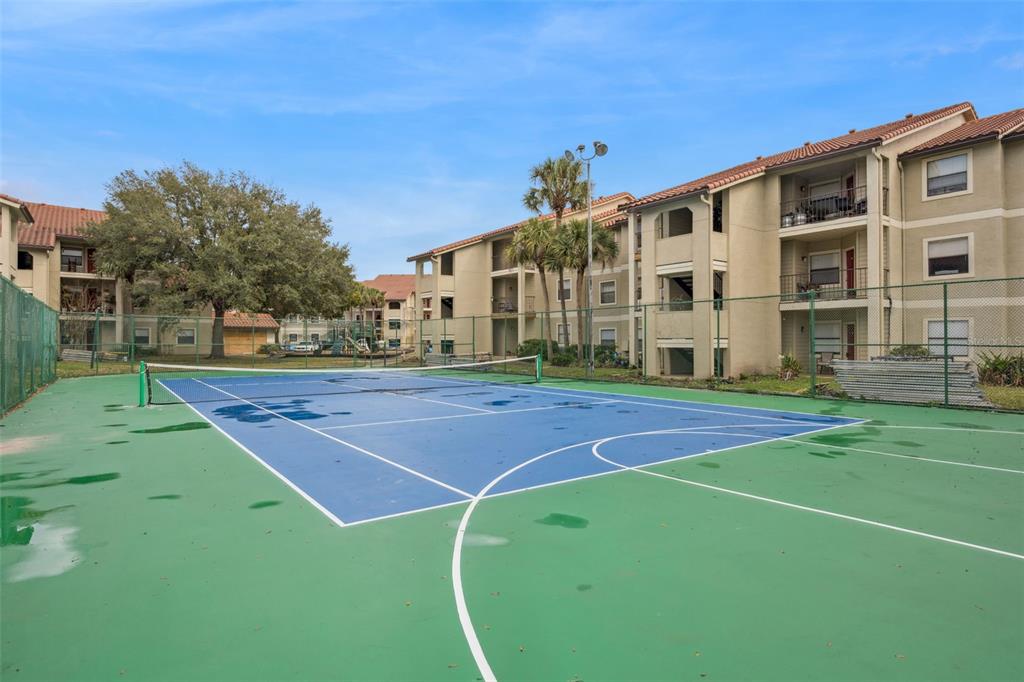 3032 Parkway Boulevard, Unit 305 Kissimmee, FL 34747 - Photo 26 of 40 a view of a tennis ground with large trees