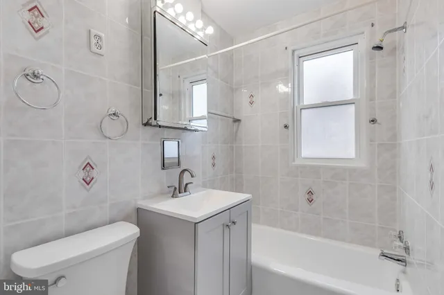 a bathroom with a toilet sink vanity tub and shower
