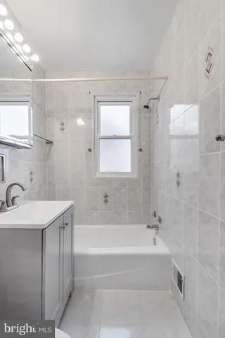 a spacious bathroom with a bathtub sink and mirror