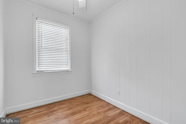 an empty room with wooden floor and a window