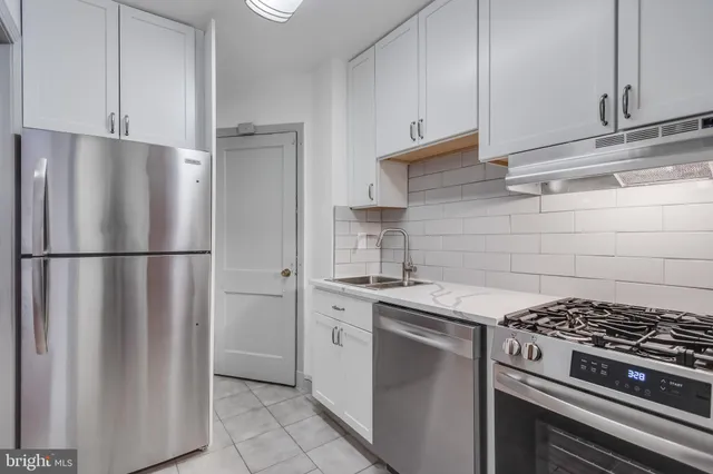 a kitchen with stainless steel appliances granite countertop a stove and a refrigerator