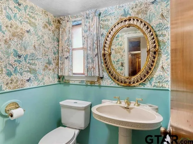 a bathroom with a toilet sink and mirror