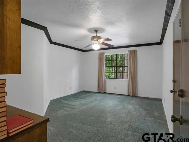 an empty room with windows and fan