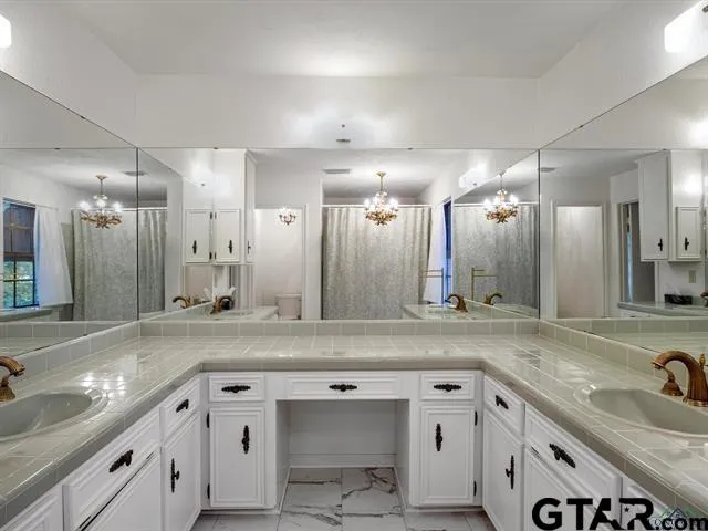a view of a sink and a large mirror in a room
