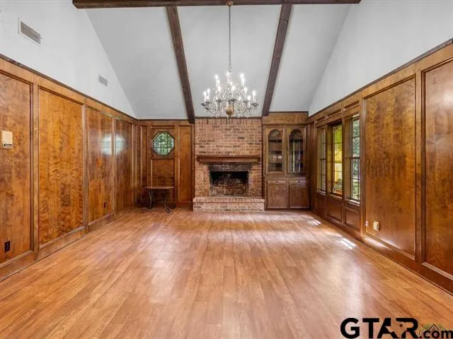 a view of an empty room with a fireplace and a window