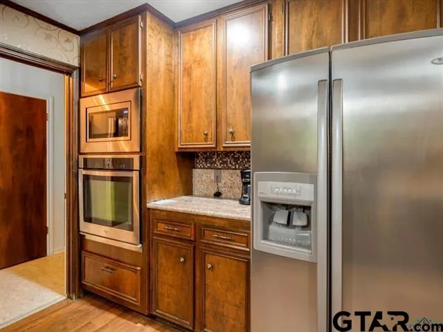 a kitchen with stainless steel appliances granite countertop a refrigerator and a stove