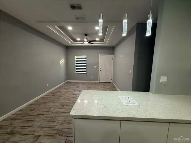 en empty room with wooden floor and ceiling fan