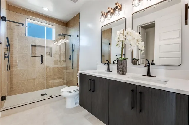 a bathroom with a double vanity sink mirror and shower