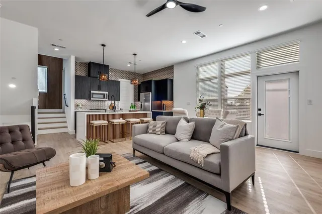a living room with furniture kitchen view and a large window