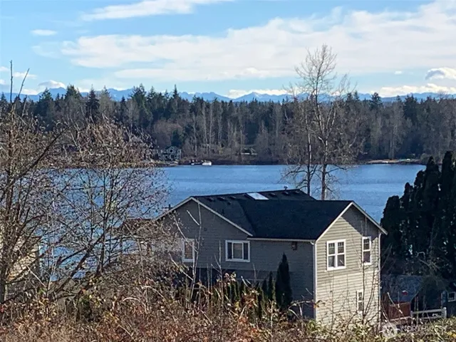a view of a house with a yard and trees