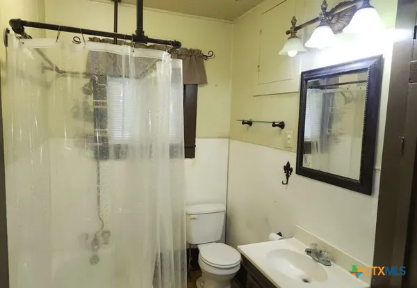 a bathroom with a shower a toilet and sink