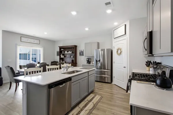 a kitchen with refrigerator a sink and chairs