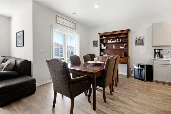 a living room with furniture a clock on wall and a window
