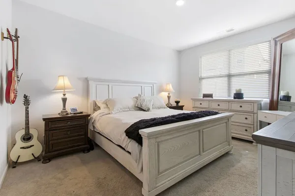 a bedroom with a large bed and a flat tv screen on a dresser