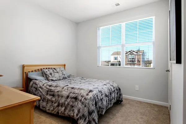 a bedroom with a bed and a dresser in it