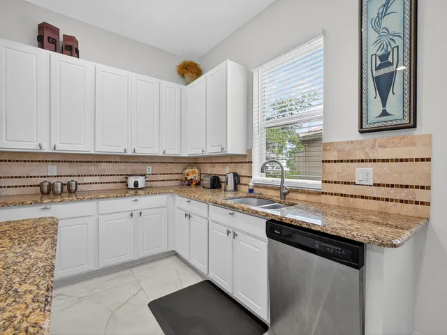 a kitchen with stainless steel appliances granite countertop a sink and a stove